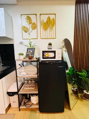 a kitchen with a microwave on top of a refrigerator at Amiela’s Place in Trece Martires