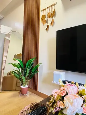 a living room with a desk with a television and flowers at Amiela’s Place in Trece Martires