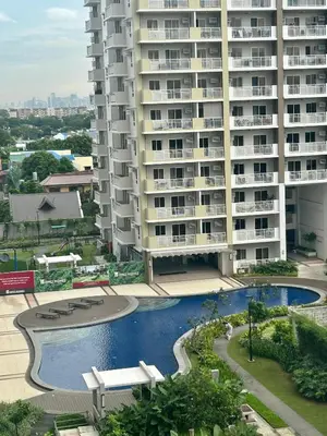 a large apartment building with a swimming pool and a building at The Atherton in Manila