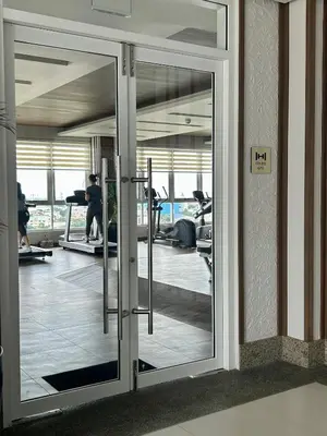 a glass door in a gym with people on machines at The Atherton in Manila
