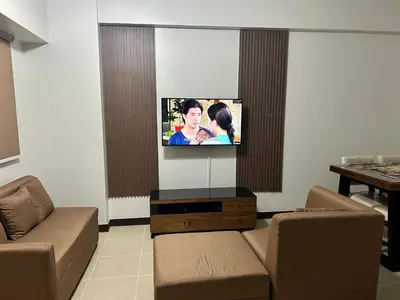 a living room with a flat screen tv on a wall at The Atherton in Manila
