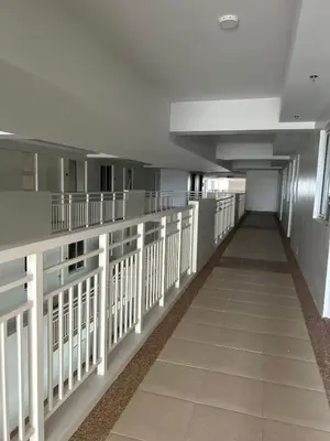 an empty hallway of a hospital with white railing at The Atherton in Manila