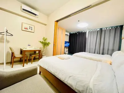 a hotel room with two beds and a table and a desk at Thompson Suites - 2 beds, One Uptown Residences 28F A - XBOX & Netflix in Manila