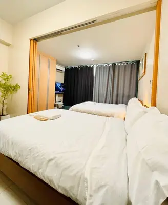two beds in a bedroom with a large mirror at Thompson Suites - 2 beds, One Uptown Residences 28F A - XBOX & Netflix in Manila