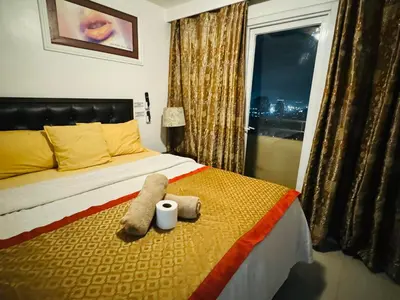 a bedroom with a bed with two towels and a window at Birch Tower a2 Front of Robinson Mall in Manila