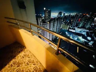 a balcony with a view of a city at night at Birch Tower a2 Front of Robinson Mall in Manila