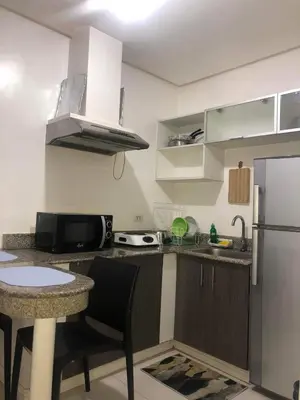 a small kitchen with a counter and a refrigerator at Birch Tower a2 Front of Robinson Mall in Manila