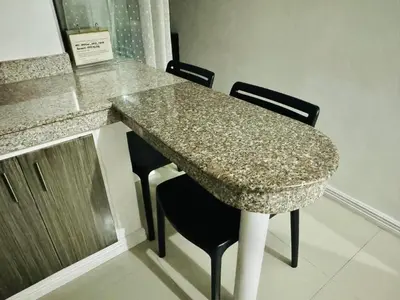 a table with two chairs and a granite counter top at Birch Tower a2 Front of Robinson Mall in Manila