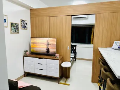 a living room with a television on a cabinet at Makati Staycation by Marco - SMDC Lush in Manila