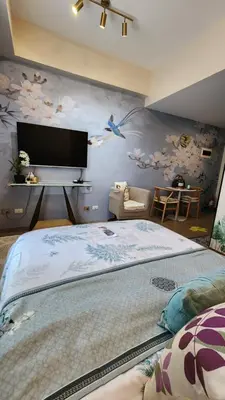 a bedroom with a large bed with a tv on the wall at Le Palis Suite in Bukal