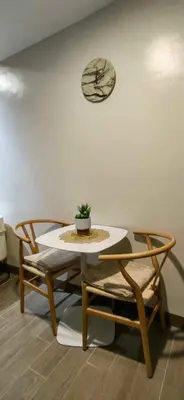 a table and two chairs and a clock on a wall at Le Palis Suite in Bukal