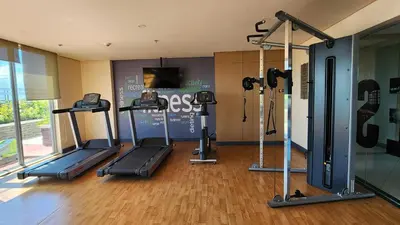 a gym with two tread machines and a tv at Le Palis Suite in Bukal