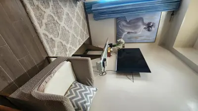 a room with a couch and a desk with a laptop at Le Palis Suite in Bukal