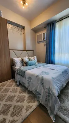 a bedroom with a bed with a blue comforter at Le Palis Suite in Bukal