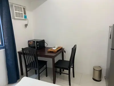 a dining room table with two chairs and a microwave at Dreamy Sunset Bay in Manila