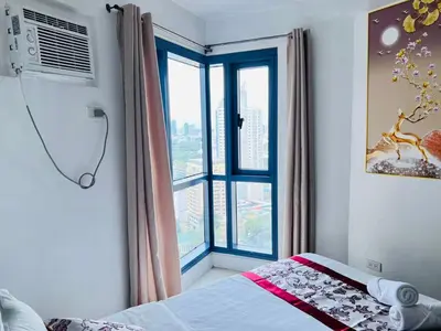 a bedroom with a bed and a large window at Dreamy Sunset Bay in Manila
