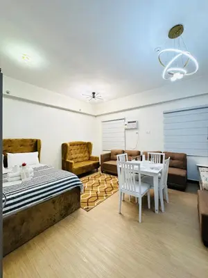 a bedroom with a bed and a table and chairs at Starlight Suites in Trece Martires
