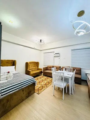 a bedroom with a bed and a table and chairs at Starlight Suites in Trece Martires