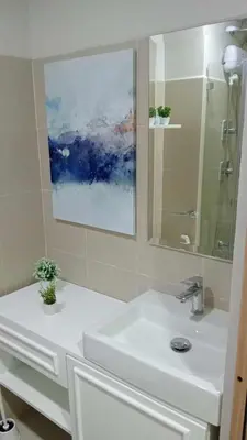 a white bathroom with a sink and a mirror at Homefort at Shore Residences in Manila