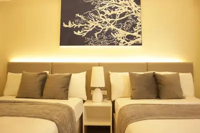 two beds sitting next to each other in a room at Homefort at Shore Residences in Manila