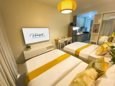 a hotel room with two beds and a tv at Homefort at Shore Residences in Manila