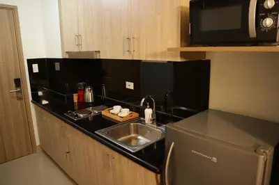 a kitchen counter with a sink and a microwave at Homefort at Shore Residences in Manila