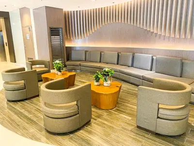a waiting room with couches and tables and chairs at Homefort at Shore Residences in Manila