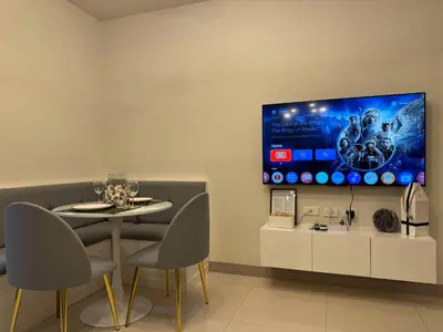 a dining room with a table and a tv on the wall at Homefort at S Residences in Manila