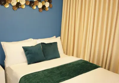 a bed with green and white sheets and pillows at Homefort at S Residences in Manila