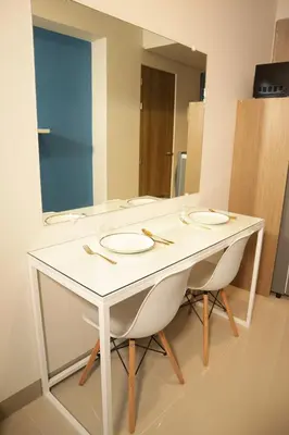 a white table with two chairs and a mirror at Homefort at S Residences in Manila
