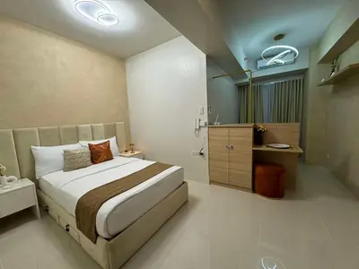 a bedroom with a large bed and a bathroom at Homefort at S Residences in Manila