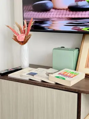 a desk with a book and a vase of flowers at A3J Staycation at Azure Urban Resort Residences in Manila