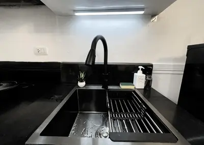 a kitchen sink with a faucet next to a sink at Cozy & Airy Suite near Venice Mall FREE Pool & Gym in Manila