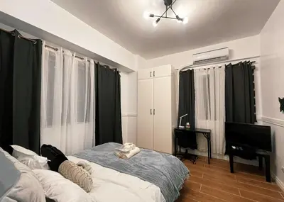a bedroom with a bed and a desk and a piano at Cozy & Airy Suite near Venice Mall FREE Pool & Gym in Manila