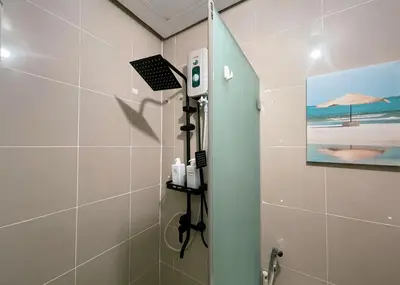 a bathroom with a shower with a picture of the beach at Cozy & Airy Suite near Venice Mall FREE Pool & Gym in Manila