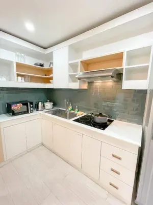 a kitchen with white cabinets and a sink at Travelers Inn - Modern Capsule Bunks, Makati in Manila