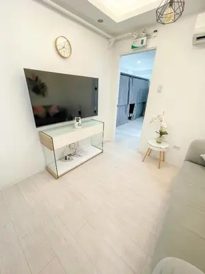 a living room with a large flat screen tv at Travelers Inn - Modern Capsule Bunks, Makati in Manila