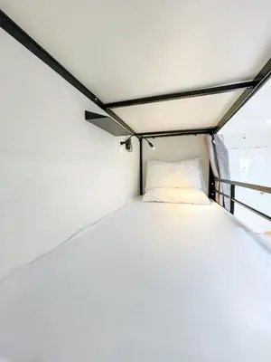 a bed in a room with a ceiling at Travelers Inn - Modern Capsule Bunks, Makati in Manila