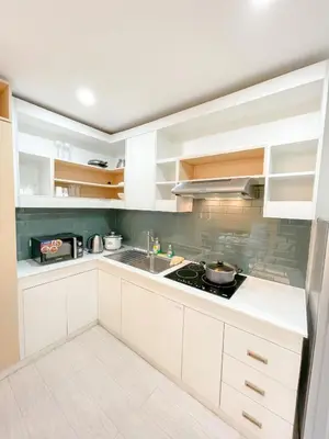 a kitchen with white cabinets and a sink at Travelers Inn - Modern Capsule Bunks, Makati in Manila