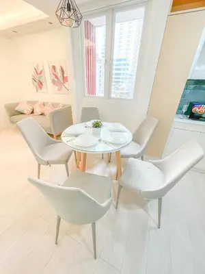 a dining room with a white table and chairs at Travelers Inn - Modern Capsule Bunks, Makati in Manila