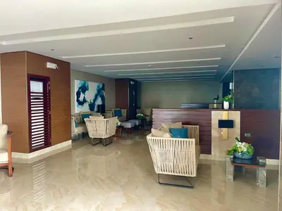 a lobby with chairs and tables in a building at SMDC Coast Residences in Manila
