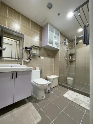 a bathroom with a toilet and a sink and a shower at SMDC Coast Residences in Manila