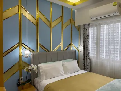 a bedroom with a bed with a yellow and blue wall at SMDC Coast Residences in Manila