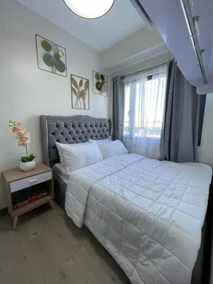a bedroom with a large bed and a window at Hope Serenity, Spring Residences Tower 3 in Manila