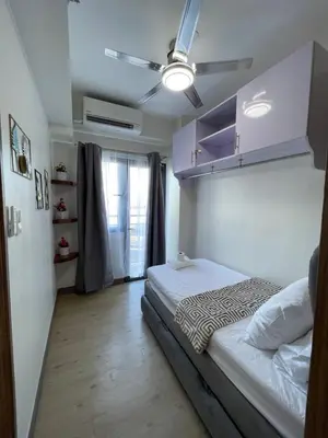 a bedroom with a bed and a ceiling fan at Hope Serenity, Spring Residences Tower 3 in Manila