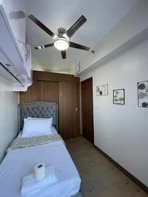 a bedroom with a bed with a ceiling fan at Hope Serenity, Spring Residences Tower 3 in Manila