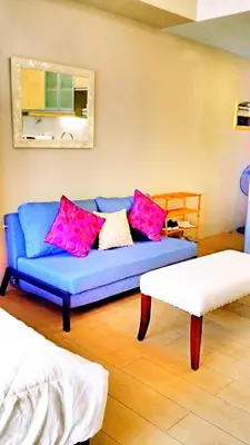 a blue couch with pink pillows in a living room at Studio-Type Condo at Eastwood Legrand 3 in Manila