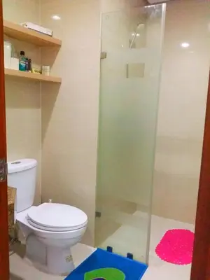 a bathroom with a toilet and a glass shower at Studio-Type Condo at Eastwood Legrand 3 in Manila