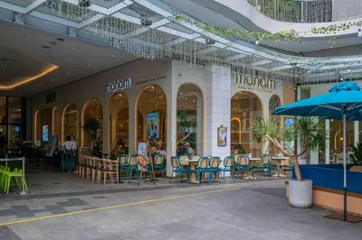a shopping mall with tables and chairs and an umbrella at 1 BR with balcony in Uptown BGC in Manila