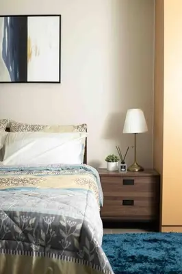 a bedroom with a bed and a nightstand with a lamp at Cozy 1BR with Balcony and Netflix in Uptown BGC in Manila